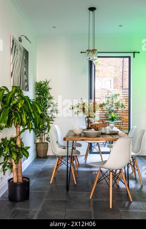 Table and chairs and plants in London flat, UK Stock Photo