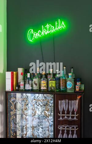 Cocktail bar with green neon light in London flat, UK Stock Photo