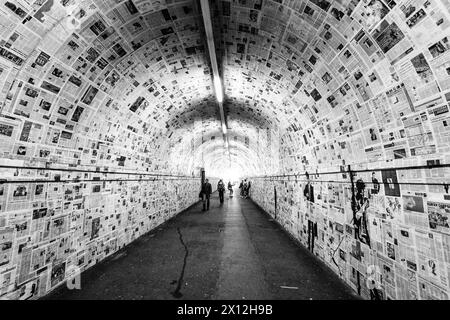 A long tunnel, covered with old newspapers on the walls,connects the train station's platforms in Lugano, Switzerland Stock Photo
