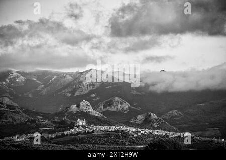 Santa Maria della neve basilica in Cuglieri, seen from far away with a mountain range and ominous clouds in background Stock Photo