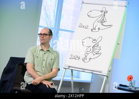 Hanover, Germany. 15th Apr, 2024. Children's book author Ingo Siegner shows how his book character Dragon Coconut has changed between 2002 and 2024 at a reading for primary school children at the Künstlerhaus Hannover. To mark the 70th anniversary of the Friedrich-Bödecker-Kreis Niedersachsen (FBK), 70 readings by authors for nurseries and schools in Lower Saxony are taking place. Children's book author Ingo Siegner read from his Drache-Kokosnuss books. Credit: Julian Stratenschulte/dpa/Alamy Live News Stock Photo