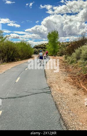 Family enjoying a bike ride on a sunny desert park trail. Stock Photo