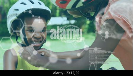 Image of data processing with digital brain over african woman and her son wearing helmets Stock Photo
