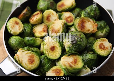 Delicious roasted Brussels sprouts in frying pan on table, closeup Stock Photo