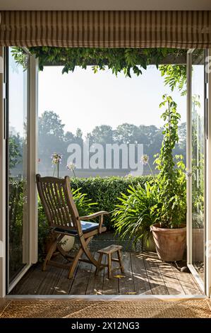 Wooden chair on waterfront terrace in Chiswick Mall with view of the river Thames, London, UK Stock Photo