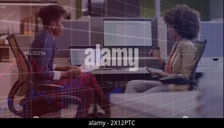 Image of statistical data processing against two diverse women discussing at office Stock Photo