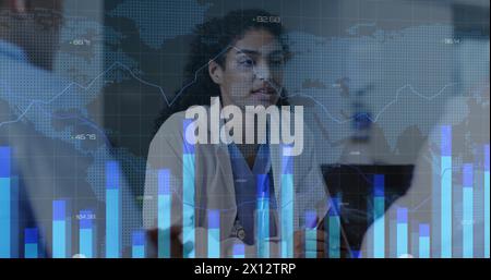 Image of graphs, changing numbers and map over diverse doctors discussing patient reports Stock Photo