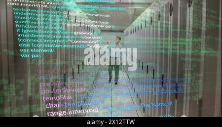 Image of computer language over caucasian male engineer walking in data server room Stock Photo