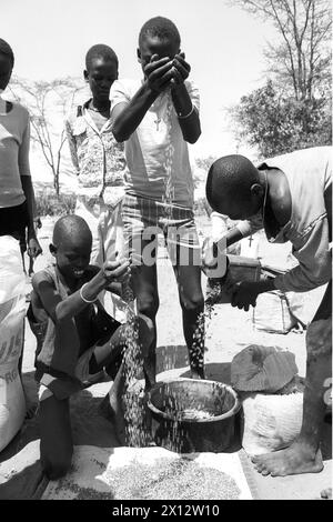 KEN , KENIA : Unbegleitete Jugendliche , die vor dem Buergerkrieg in Suedsudan geflohen sind , werden in einem Fluechtlingslager in Wajir mit Mais und Hirse versorgt , Juni 1992 KEN , KENYA : Unaccompanied youths who have fled from the civil war in South Sudan are getting corn / maize and sorghum in a refugee camp in Wajir , June 1992 *** KEN , KENIA Unaccompanied youths who have fled from the civil war in South Sudan are getting corn maize and sorghum in a refugee camp in Wajir , June 1992 KEN , KENYA Unaccompanied youths who have fled from the civil war in South Sudan are getting corn maize Stock Photo