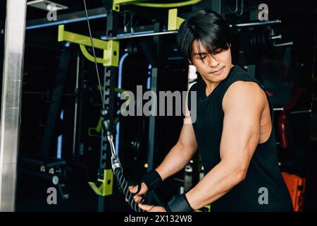 Young man performing cable triceps pulldowns to build muscle and strength Stock Photo