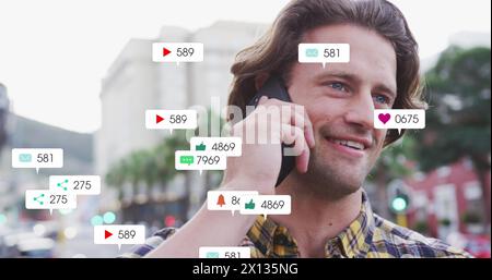 Image of social media icons over caucasian man using smartphone Stock Photo