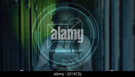 Image of message block icon over african american female engineer using tablet at server room Stock Photo
