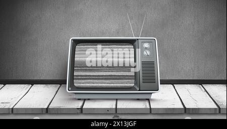 Digital image of an old television with static placed on a wooden deck Stock Photo