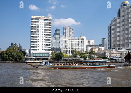 Passenger Ferry Boat on the Chao Phraya River in front of the Mandarin Oriental Hotel in Bangkok Thailand Stock Photo