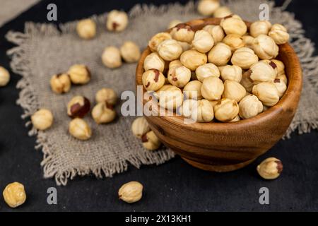 peeled roasted hazelnuts in a wooden bowl, close-up of roasted hazelnuts Stock Photo