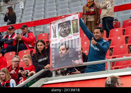 Leverkusen, North Rhine-Westphalia, Germany. 14th Apr, 2024. Bayer Leverkusen fans hold up a sign reading 37 days (until the Europa League Final), 40 days (until the DFB Pokal Final), 90 minutes (before winning the Bundesliga title), with a picture of team head coach XABIER ALONSO with a message that reads ''our dreams'' before the Bundesliga matchday 29 match between Bayer Leverkusen and Werder Bremen in the BayArena in Leverkusen, North Rhine-Westphalia, Germany on April 14, 2024. Credit: ZUMA Press, Inc./Alamy Live News Stock Photo