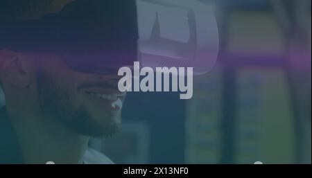 Image of blue and pink light trails moving over biracial man wearing vr headset Stock Photo
