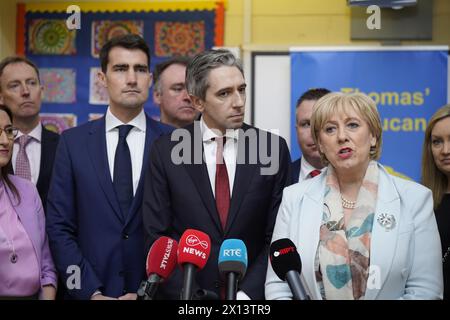 Taoiseach Simon Harris and Minister for Social Protection and Rural and Community Development Heather Humphreys speaking to the media during the announcement at St Thomas' Junior National School, Esker, Lucan, on the roll-out of the Hot School Meals Programme. Picture date: Monday April 15, 2024. Stock Photo