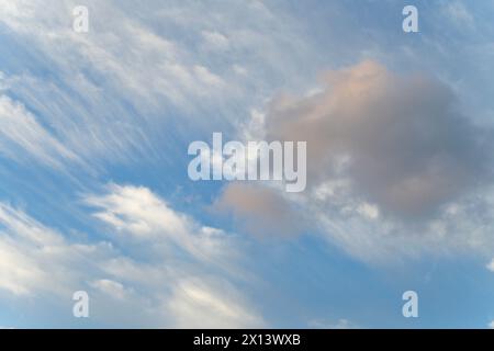 A tranquil sky scene with soft orange clouds against a clear blue backdrop Stock Photo