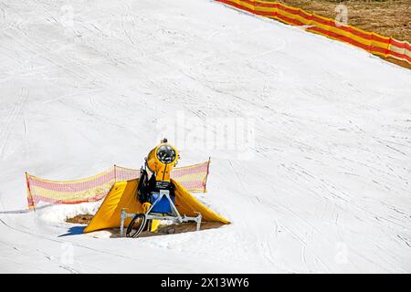 yellow snow generator on a snow slope at a resort on a sunny day. Active recreation Stock Photo