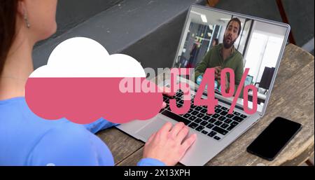 Image of cloud upload icon against rear view of woman having a image call on laptop at a cafe Stock Photo