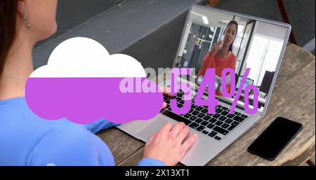 Image of cloud upload icon against rear view of woman having a image call on laptop at a cafe Stock Photo