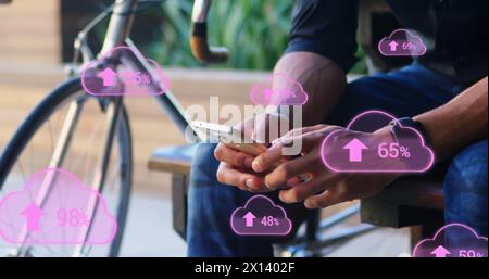 Image of digital clouds with percent going up over man using smartphone Stock Photo