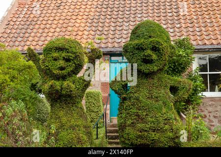 Male and female topiary figures in the village of Stenton Stock Photo
