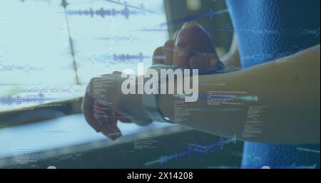 Image of data processing on screens over caucasian woman checking smartwatch Stock Photo