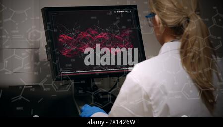 Image of chemical formulas over back view of caucasian female lab worker using computer Stock Photo