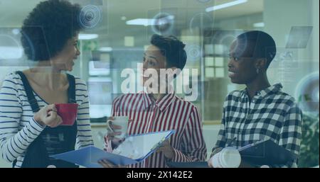 Image of hud processing over multiracial female colleagues discussing files during coffee break Stock Photo