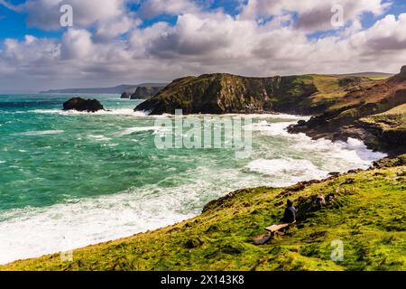 Storm watcher looking out on crashing waves in the Gullastem cove in the wake of Storm Kathleen - taken from Barras Nose, Tintagel, Cornwall, UK Stock Photo