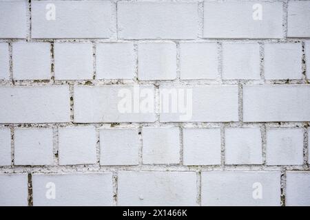 A white brick wall in daylight and cloudy weather. Stock Photo