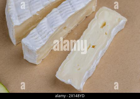 soft processed cheese with white mold on the table, sliced white cheese with mold close-up Stock Photo