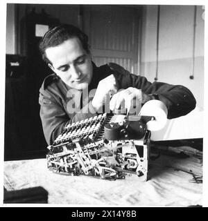 THE ACTIVITIES OF THE ROYAL ELECTRICAL AND MECHANICAL ENGINEERS - Craftsmen Lewis of Bournemouth was a typewriter mechanic and the Army uses him much in the same job. Here he is seen attending to a Burroughs Adding Machine British Army Stock Photo
