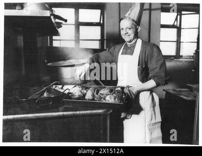 SOLDIERS EARN THEIR CHRISTMAS DINNER - The unit's cook roasting the birds in the kitchen British Army Stock Photo