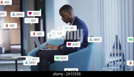 Image of notification bars over african american man working on laptop in office Stock Photo