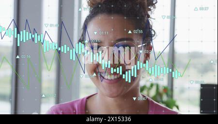 Image of multiple graphs with changing numbers over smiling woman Stock Photo