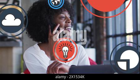 Image of icon in circles over biracial woman laughing and talking on cellphone Stock Photo