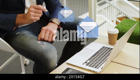 Image of envelope icons over man using smartwatch and laptop Stock Photo