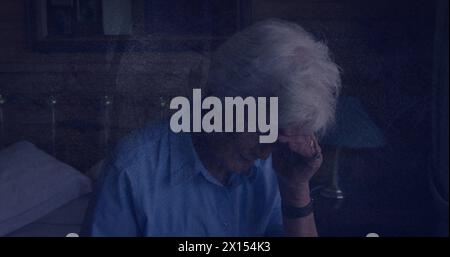 Image of moving shapes over senior caucasian woman touching her forehead Stock Photo