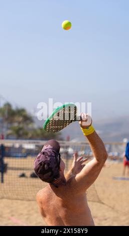 50 year old man playing beach tennis in summer Stock Photo