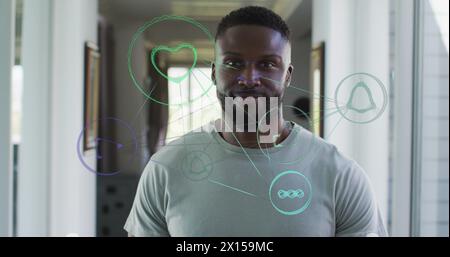 Image of connections with icons over african american man smiling at camera Stock Photo