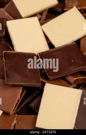 mixed together different types of chocolate, white, bitter and milk chocolate pieces Stock Photo