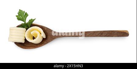 Tasty butter curls and fresh parsley in spoon isolated on white, top view Stock Photo