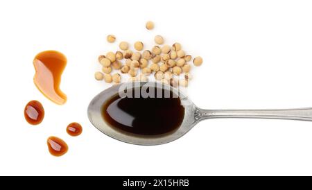 Tasty soy sauce in spoon and soybeans isolated on white, top view Stock Photo