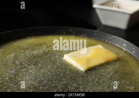 Melting butter in frying pan on table, closeup Stock Photo