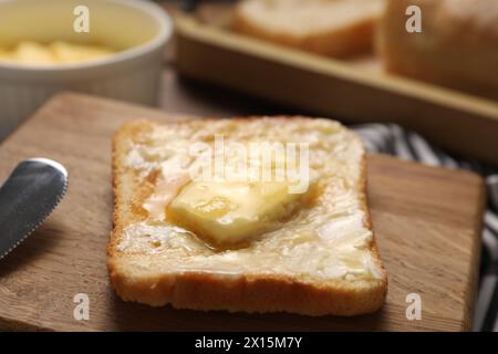 Melting butter, toast and knife on table, closeup Stock Photo