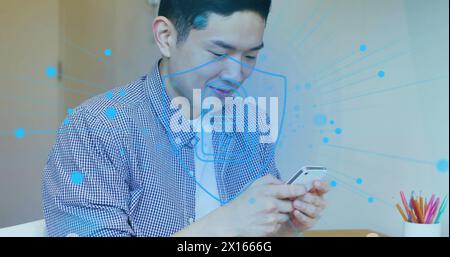 Image of padlock icon with connections over asian man using smartphone Stock Photo