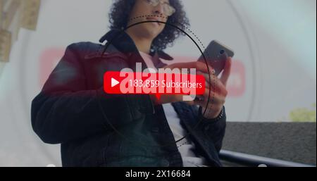 Image of subscribers text, play icon with increasing numbers over biracial man using smartphone Stock Photo